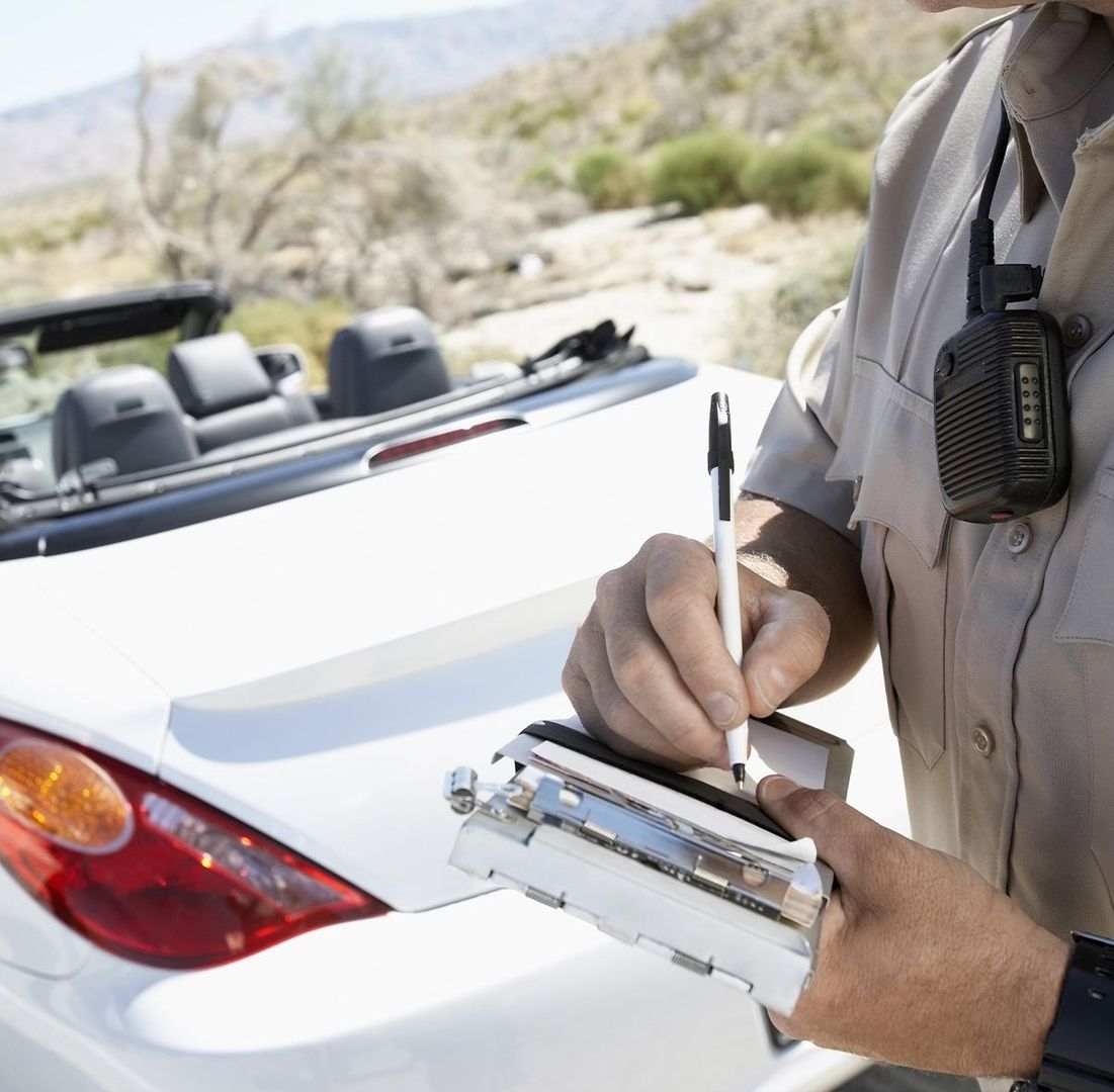 Ein Polizist hat ein Auto angehalten und schreibt einen Strafzettel