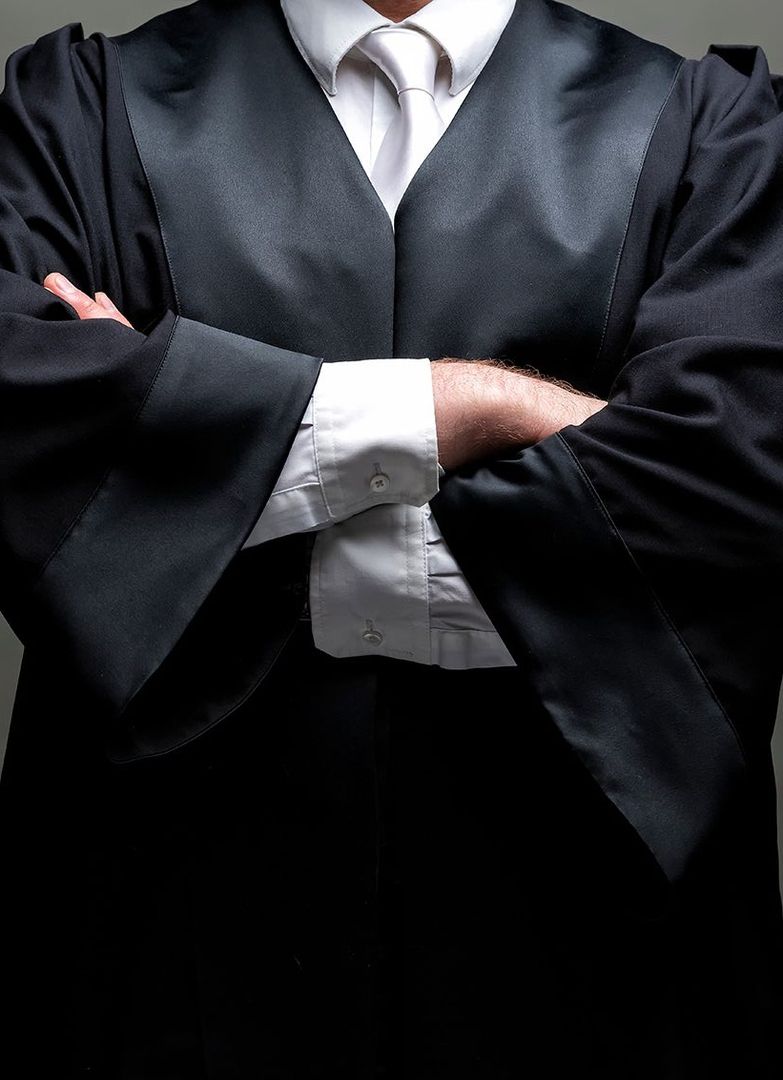 Ein Richter mit verschrenkten Armen und schwarzem Gewand